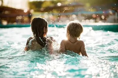 two children in the water in a swimming pool at Candlewood Suites Orlando North - Winter Park by IHG in Orlando