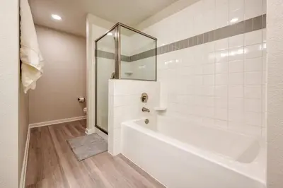 a white bathroom with a tub and a shower at Conforto e Estilo | 3Q Piscina & Resort in Orlando