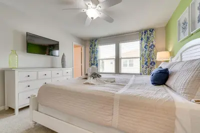 a bedroom with a white bed and a tv at 4 Mi to WDW Sleek Townhome with Community Pool! in Kissimmee