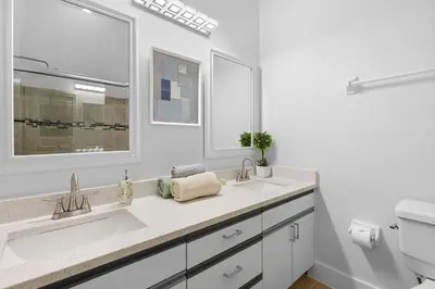 a white bathroom with two sinks and a toilet at Enjoy your Summer Near to Disney- Universal-Epic in Kissimmee