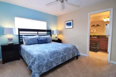 a bedroom with a bed with a blue comforter at Fully Equipped Comfortable Townhouse in Kissimmee