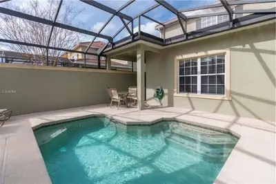 a swimming pool in the backyard of a house at Fully Equipped Comfortable Townhouse in Kissimmee