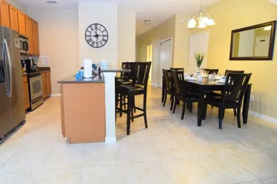 a kitchen and dining room with a table and chairs at Fully Equipped Comfortable Townhouse in Kissimmee