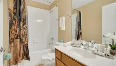 a bathroom with a sink and a toilet and a shower at Disney Retreat w/ Wizard & Galaxy Rooms in Orlando