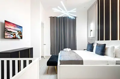 a white bedroom with a bed and a crib at Themed Kids' Rooms, Pool & Game Loft Near Disney in Kissimmee