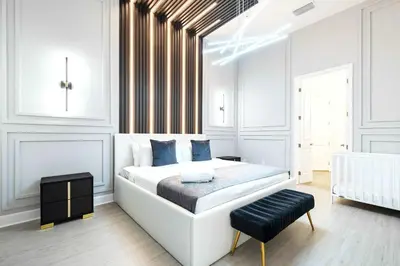 a white bedroom with a large bed and a stool at Themed Kids' Rooms, Pool & Game Loft Near Disney in Kissimmee