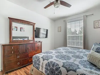 a bedroom with a bed and a dresser and a tv at Windsor Hills Modern 3BR Condo with Resort Amenities in Orlando