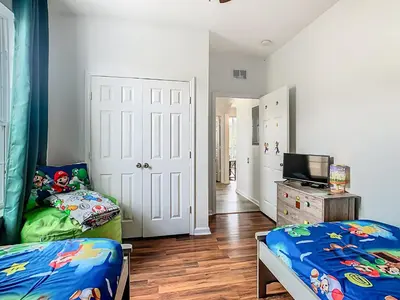 a bedroom with two beds and a television in it at Windsor Hills Modern 3BR Condo with Resort Amenities in Orlando