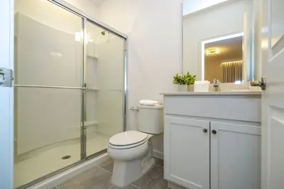 a bathroom with a toilet and a glass shower at Paradiso Grande 5 Bed New Townhome - 10329 in Orlando