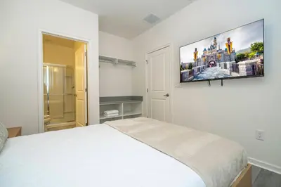 a bedroom with a bed and a flat screen tv on the wall at Paradiso Grande 5 Bed New Townhome - 10329 in Orlando
