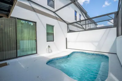 an indoor swimming pool in a house with a large window at Paradiso Grande 5 Bed New Townhome - 10329 in Orlando