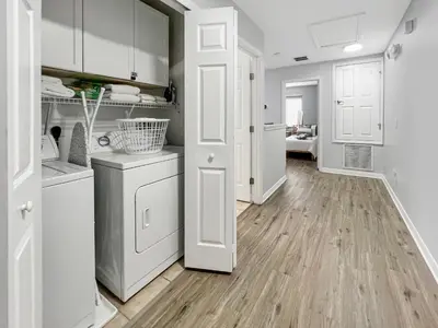 a kitchen with white cabinets and a wooden floor at Rumi Haven-Homey&Spacious Stay in Orlando