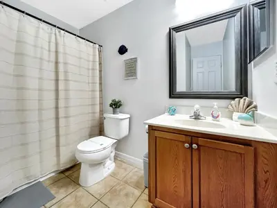 a bathroom with a toilet and a sink and a mirror at Rumi Haven-Homey&Spacious Stay in Orlando