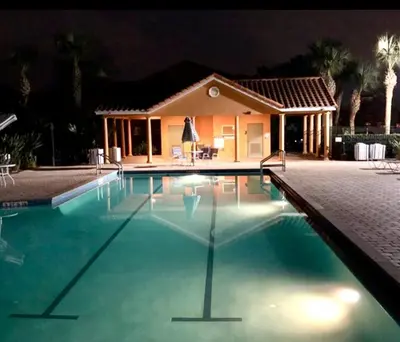 a swimming pool in front of a house at night at Rumi Haven-Homey&Spacious Stay in Orlando