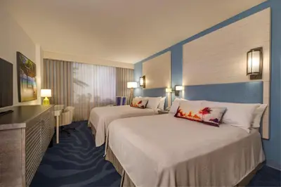a hotel room with two beds and a television at Universal's Loews Sapphire Falls Resort in Orlando