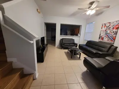 a living room with black leather furniture and a ceiling fan at SHVPC3 - Paradise Cay #3 - 3 Bed 2.5 Baths Townhome in Kissimmee
