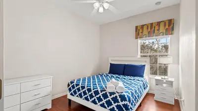 a bedroom with a bed with blue sheets and a ceiling fan at SHVCK1 - Coral Cay Resort #1 - 4 Bedroom Townhouse in Kissimmee