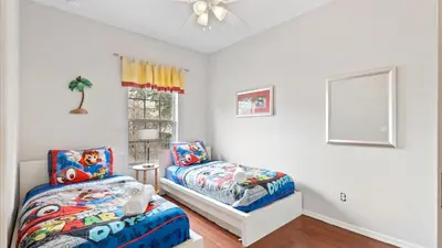 a bedroom with a bed and a chair and a window at SHVCK3 - Coral Cay Resort #3 - 4 Bed 3 Baths Townhome in Kissimmee