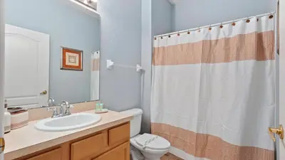 a bathroom with a sink and a toilet and a shower curtain at SHVCK4 - Coral Cay Resort #4 - 4 Bed 3 Baths Townhome in Kissimmee
