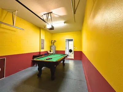 a pool table in a room with yellow and red walls at SHVPP1 - Paradise Palms #1 - 6 Bed 5 Baths Villa in Kissimmee