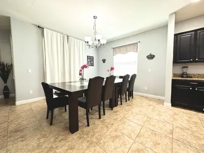 a dining room with a black table and chairs at SHVPP1 - Paradise Palms #1 - 6 Bed 5 Baths Villa in Kissimmee