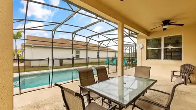 a patio with a glass table and chairs and a pool at SHVCC2 - Crystal Cove #2 - 7 Bed 4.5 Baths Villa in Kissimmee
