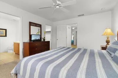 a bedroom with a bed and a ceiling fan at Spacious Lakefront Townhouse 10 Mins To Disney in Kissimmee