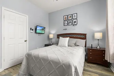 a bedroom with a bed and two lamps and a tv at Cozy 3Br Villa With Pool Disney Nearby in Orlando