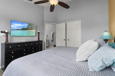 a bedroom with a bed with a tv on the wall at Cozy 3Br Villa With Pool Disney Nearby in Orlando