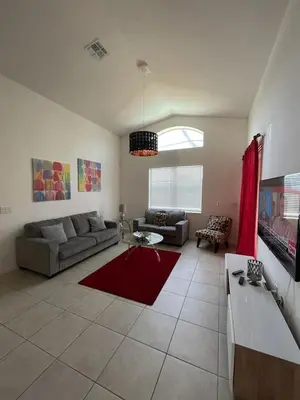a living room with a couch and a red rug at Luxury Family Villa With Pool & Bbq Near Disney! in Kissimmee