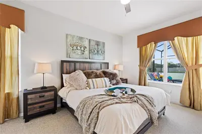 a bedroom with a large bed and a window at 4Br Pool Villa, Near Disney - Gated Resort! in Kissimmee