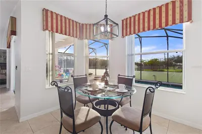 a dining room with a glass table and chairs at 4Br Pool Villa, Near Disney - Gated Resort! in Kissimmee