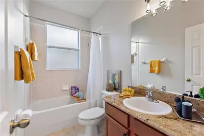 a bathroom with a sink and a tub and a toilet at 4Br Pool Villa, Near Disney - Gated Resort! in Kissimmee