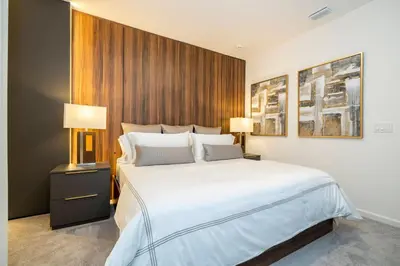 a bedroom with a large white bed and two lamps at Brand New 12 Bedrooms Single Family Paradiso 85HI in Orlando