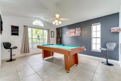 a room with a pool table and two chairs at 4 Mi to Disney Home with Pool Table, Outdoor Oasis! in Orlando