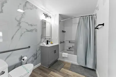 a white bathroom with a shower and a toilet at 1 BR1 Bath sleeps 6 Close to Universal Parks in Orlando