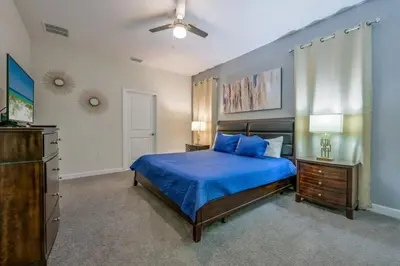 a bedroom with a blue bed and a dresser at Casa9 quartos p/ família+Temas c/ piscina in Kissimmee