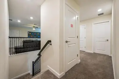 a hallway with a door and a staircase with a couch at Casa9 quartos p/ família+Temas c/ piscina in Kissimmee
