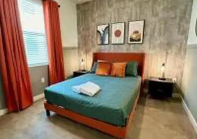 a bedroom with a bed and a red curtain at 3231 ED - The Hub Modern 3BR in Kissimmee