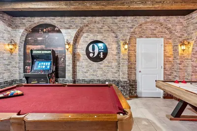 a pool table in a room with a brick wall at NEW Home 09 BedroomsPoolGame Room in Kissimmee