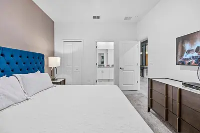 a bedroom with a large bed and a blue headboard at NEW Home 09 BedroomsPoolGame Room in Kissimmee