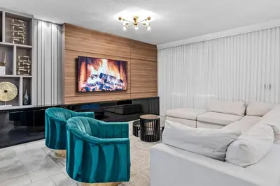 a living room with a white couch and blue chairs at NEW Home 09 BedroomsPoolGame Room in Kissimmee