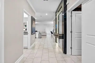 a hallway with white walls and a tile floor at NEW Home 09 BedroomsPoolGame Room in Kissimmee