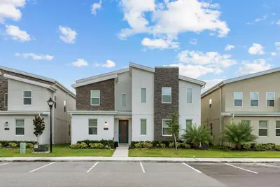 a row of apartment buildings with a parking lot at NEW Home 09 BedroomsPoolGame Room in Kissimmee