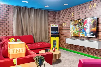 a living room with a red couch and a tv at Amazing 06 Bedrooms3 BathSleeps 14 in Kissimmee