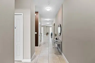 a hallway with white walls and a tile floor at Amazing 06 Bedrooms3 BathSleeps 14 in Kissimmee