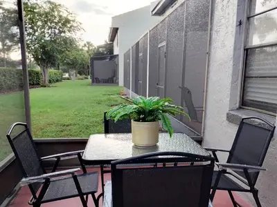 a table with chairs and a potted plant on a patio at Family Townhouse with Waterpark - Minutes from Disney in Kissimmee