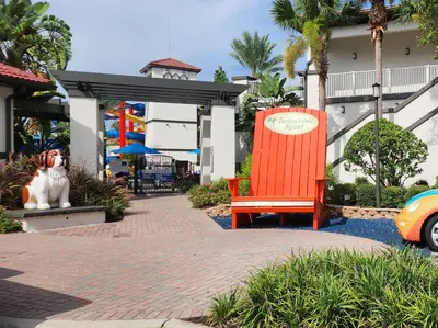 a dog sitting next to a red chair in front of a building at Family Townhouse with Waterpark - Minutes from Disney in Kissimmee