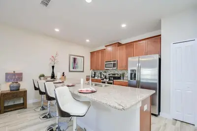 a kitchen with a large island with bar stools at Casa 4Q Piscina Privativa — Storey Lake Resort in Kissimmee
