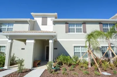 a white house with palm trees in front of it at Casa 4Q Piscina Privativa — Storey Lake Resort in Kissimmee
